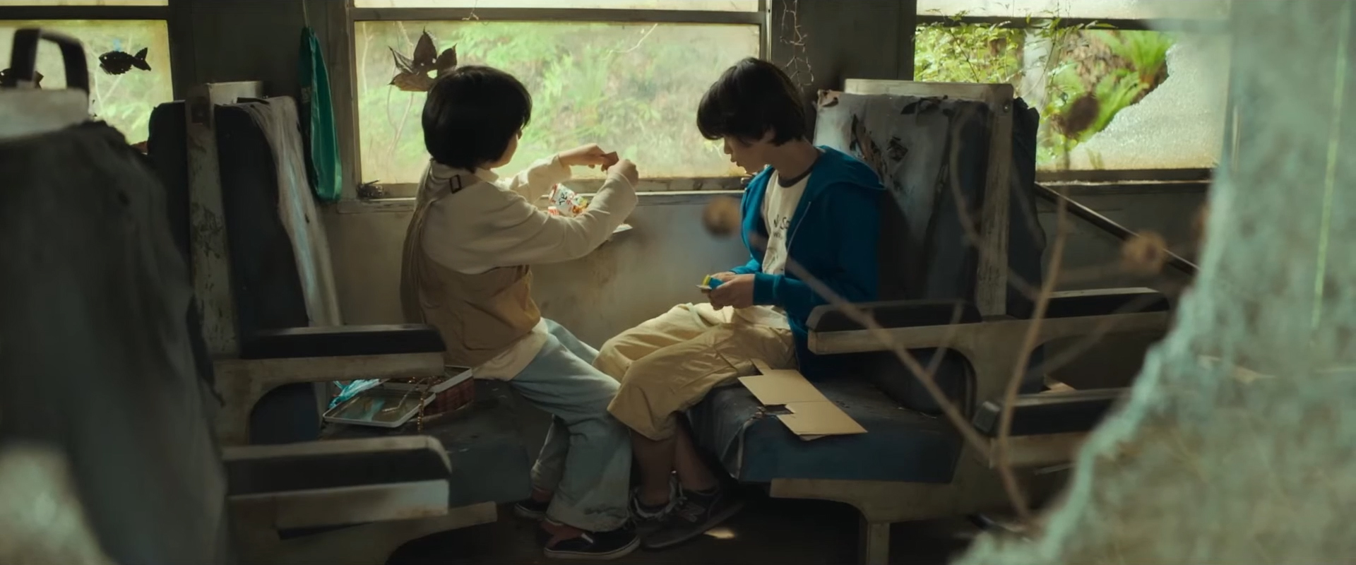 Minato and Yori sit in an abandoned train car.
