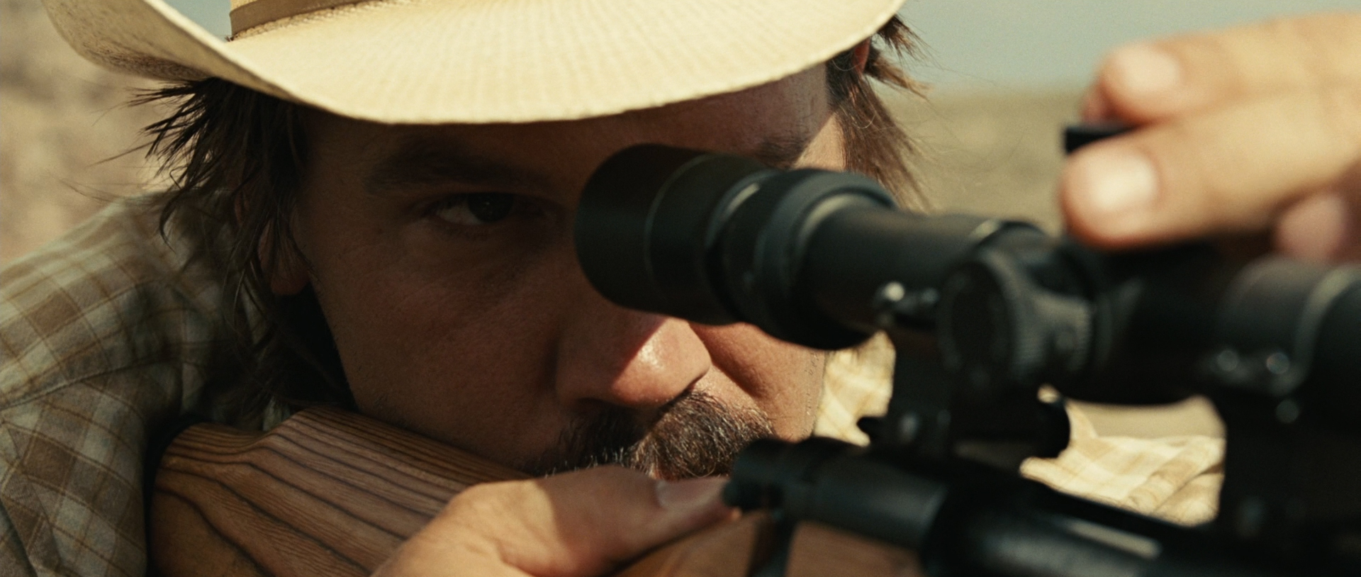 Llewelyn aims down the scope of his rifle.