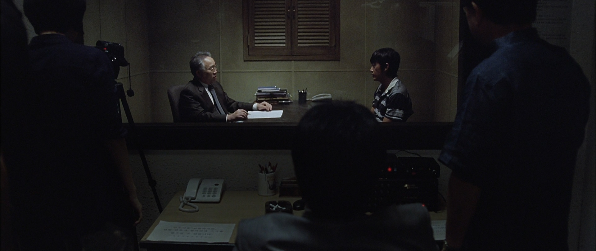 Yeong-min is interrogated by the police.